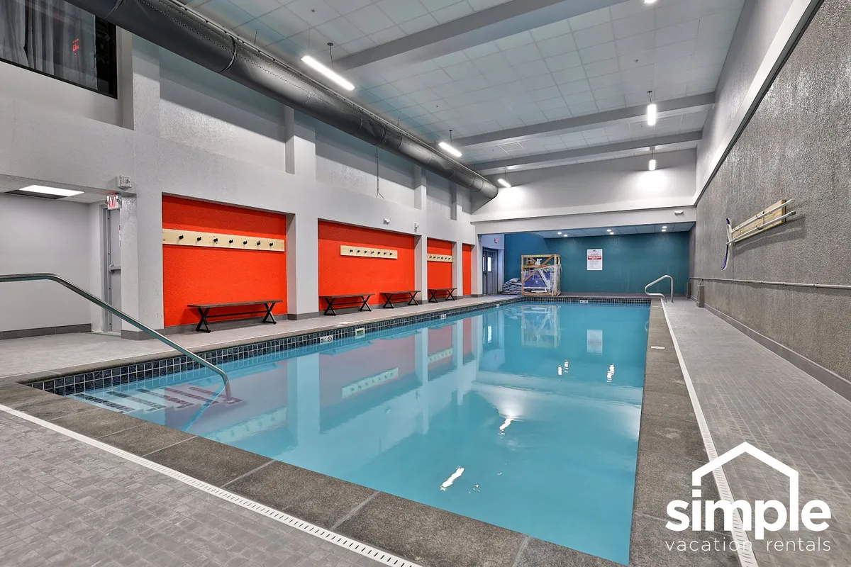 A heated indoor swimming pool with bright, inviting colors and a comfortable seating area. The pool is well-lit and designed for relaxation and leisurely swims, echoing the section’s mention of a heated indoor pool as a key couple-friendly amenity.