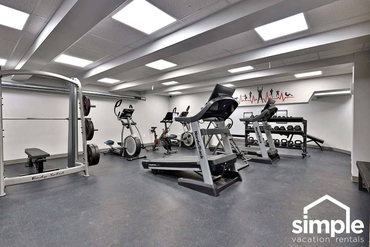 A modern, spacious fitness center with cardio machines, weightlifting equipment, and ample open space. The environment is clean, well-lit, and motivational, suggesting both individual workouts and group fitness activities.