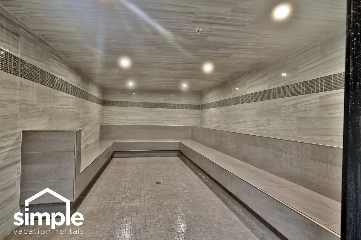 This image features smooth marble walls, ambient lighting, and spacious seating areas, creating a tranquil and spa-like atmosphere ideal for relaxation. The setting evokes the calm and rejuvenation guests might experience in a steam room or relaxation lounge.